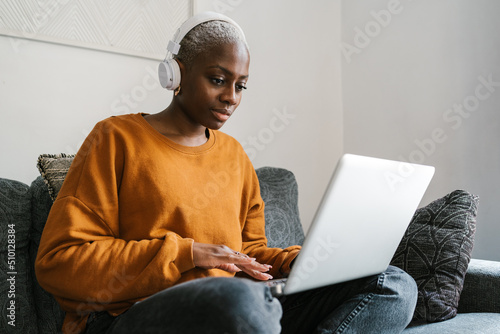 Woman in headphones working on laptop