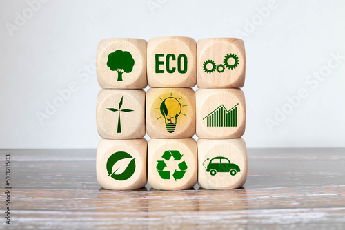 Carbon ecological footprint symbols on wooden cube with eco friendly icon. photo