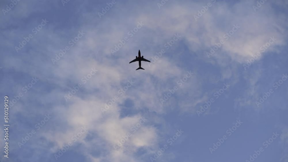 Airplane flying in the sky during sunset. Plane crossing cloudy sky Airplane flying in the sky during sunset. Plane crossing cloudy sky