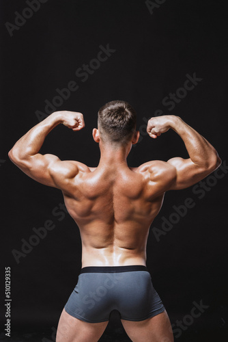 Strong man showing back double biceps at camera photo