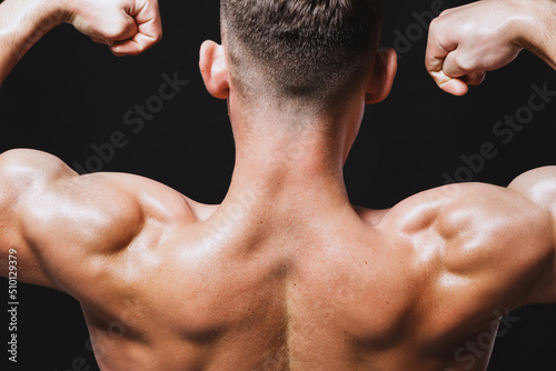Athletic back of muscular male trainer photo