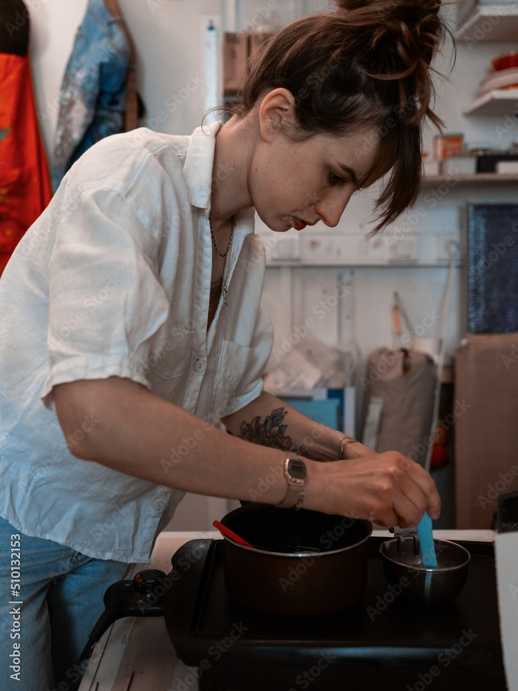 Young women work with hot wax in art studio Young women work with hot wax in art studio