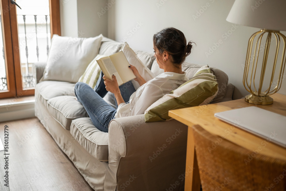 Caucasian young woman reading a book at home Caucasian young woman reading a book at home