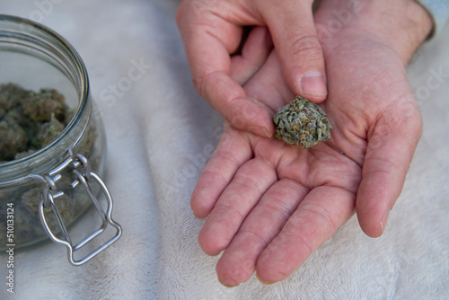 Man holding large cannabis bud in his hand