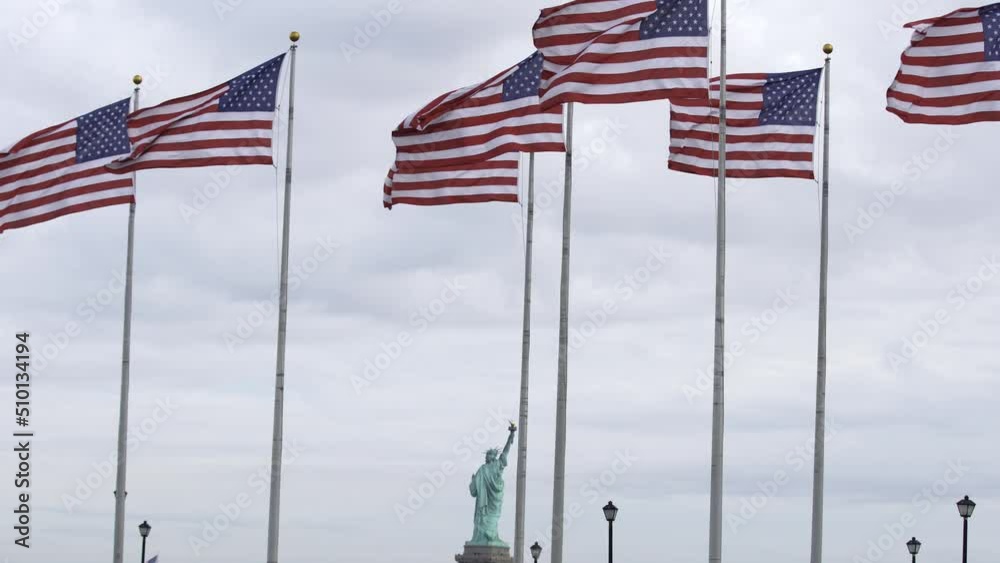 US flags flying in the wind. Statue of Liberty in the Background. Freedom and liberty US flags flying in the wind. Statue of Liberty in the Background. Freedom and liberty