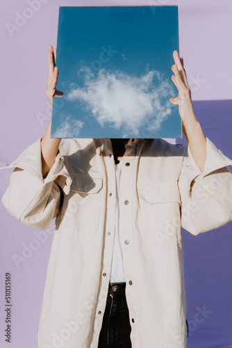 Person Covering His Face With Mirror Reflecting A Cloud