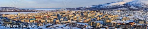 Panorama of Magadan city. Top view of a large northern city. Beautiful cityscape with many buildings. In the distance are mountains and a sea bay. Magadan, Siberia, Far East of Russia. Panoramic photo