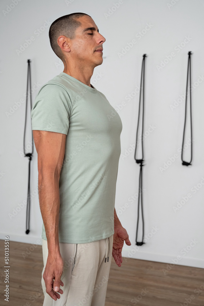Man doing breathing exercise in yoga studio Man doing breathing exercise in yoga studio