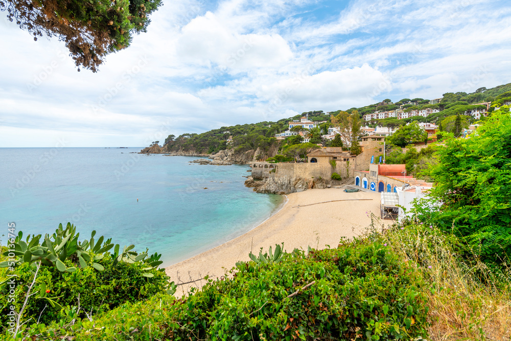 A small sandy beach at the whitewashed village of Calella de Palafrugell on the Costa Brava coastline of Southern Spain in the Catalonian region.