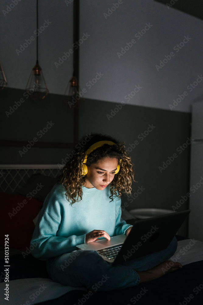 Young woman watching video on netbook at night Young woman watching video on netbook at night