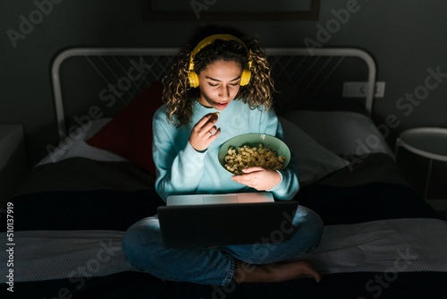 Young woman watching movie at night photo