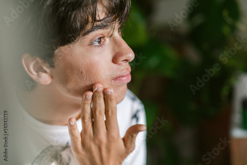 Teen boy massaging his face portrait photo