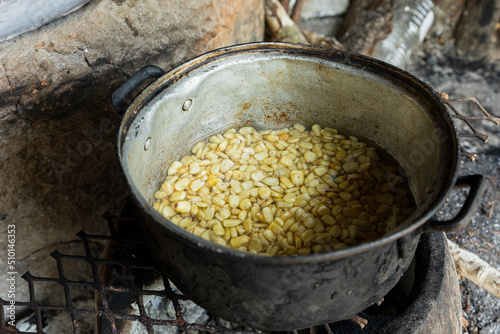 An aluminum pot with nixtamal inside which is cooking corn photo