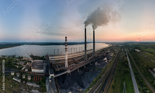 Aerial view of coal power plant high pipes with black smokestack polluting atmosphere. Electricity production with fossil fuel concept © bilanol