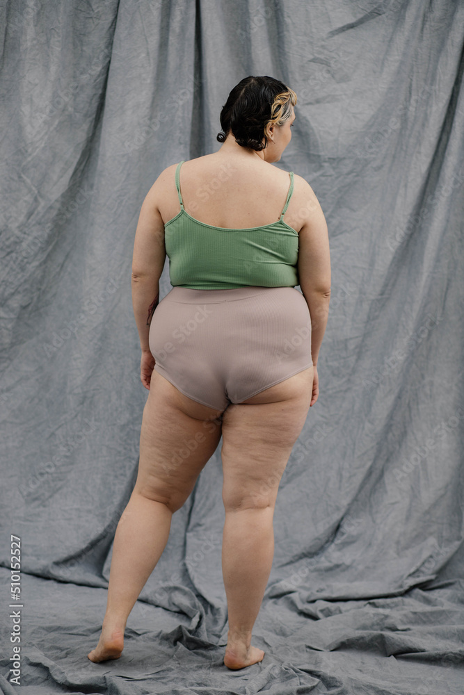 Unrecognizable plus size woman stands with her back to the camera Unrecognizable plus size woman stands with her back to the camera