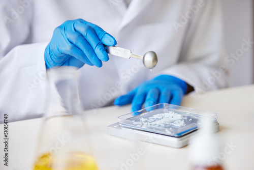 Faceless specialist weighing chemical ingredient
