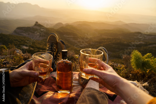 Couple sharing drink at sunset in the mountain photo