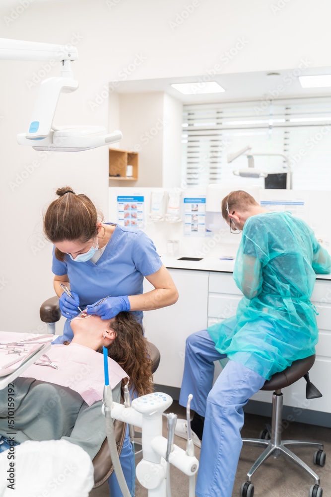 Two Dentists Performing Orthodontic Treatment Two Dentists Performing Orthodontic Treatment