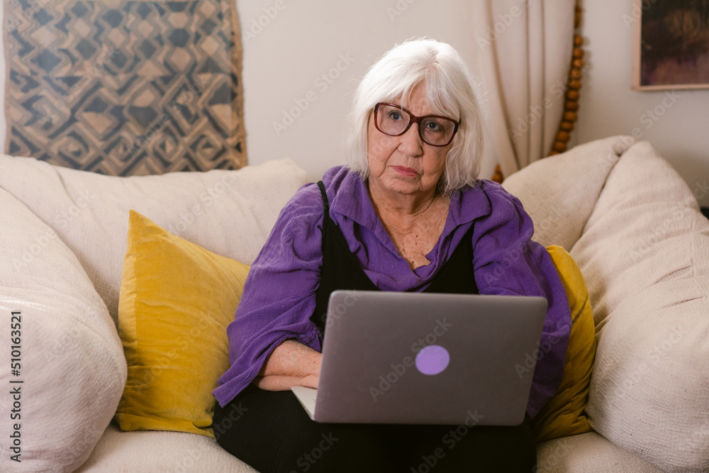 Hoary intellectual woman with laptop at living room Hoary intellectual woman with laptop at living room