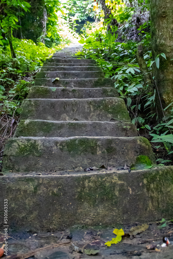 A steep staircase made of cement and stone that sits on a mountain cliff