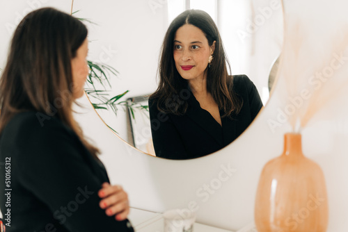 Woman looking at herself in the mirror photo