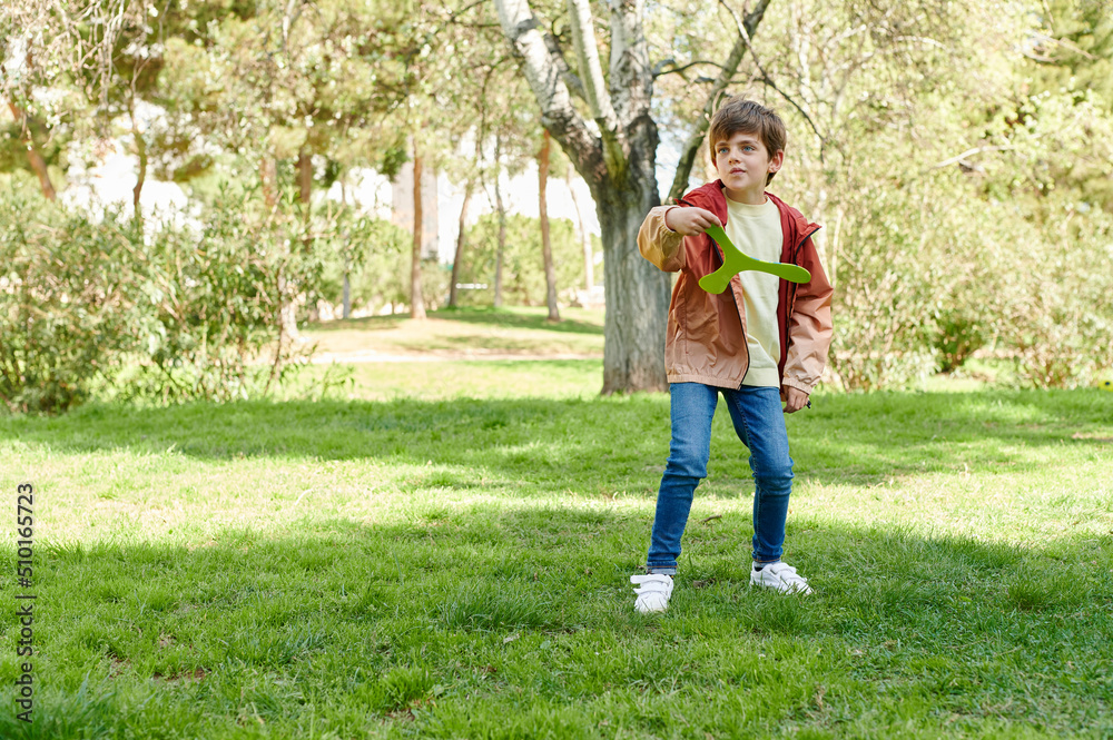 Boy throwing a boomerang outside in a park Boy throwing a boomerang outside in a park
