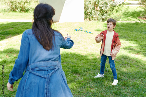 Boy catching a toy boomerang from his mom photo