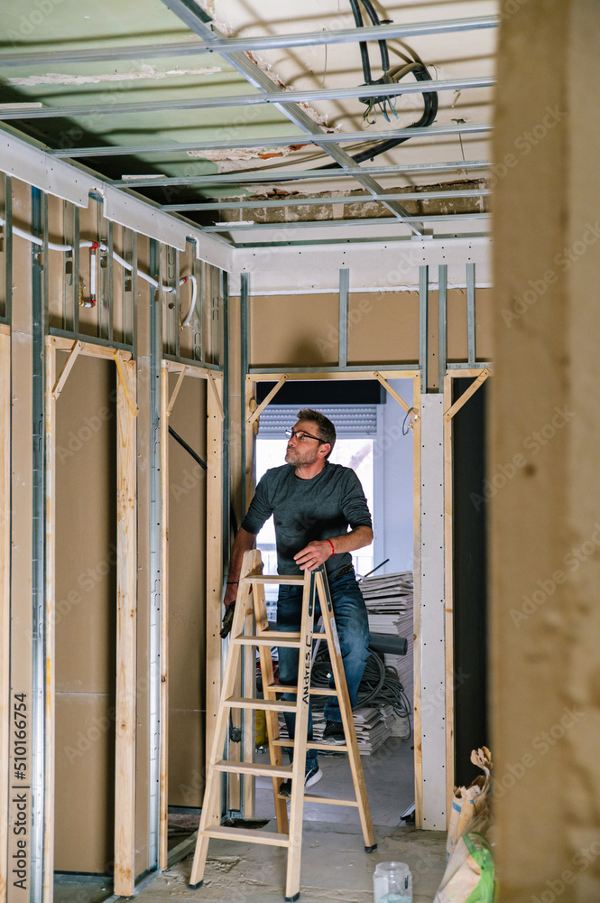 Man installing wall piping in new apartment Man installing wall piping in new apartment
