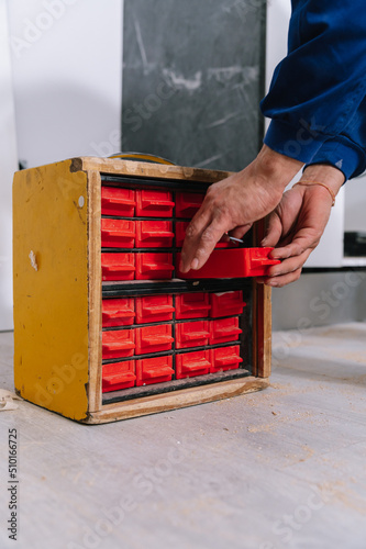 Crop worker taking box from tool organizer photo