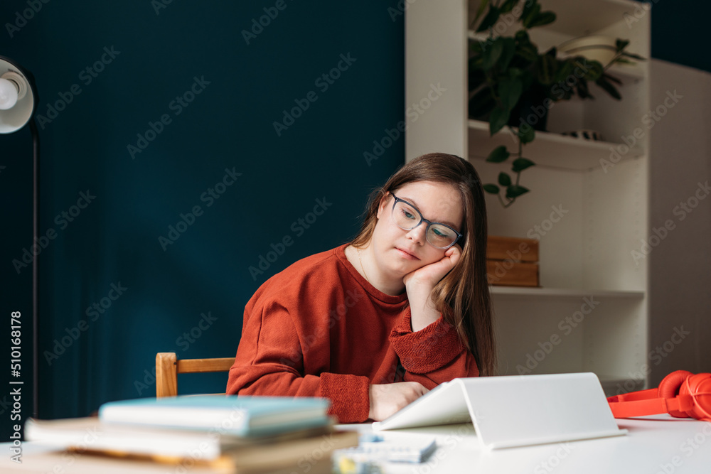 Girl with Down Syndrome Sitting at Work Table Girl with Down Syndrome Sitting at Work Table