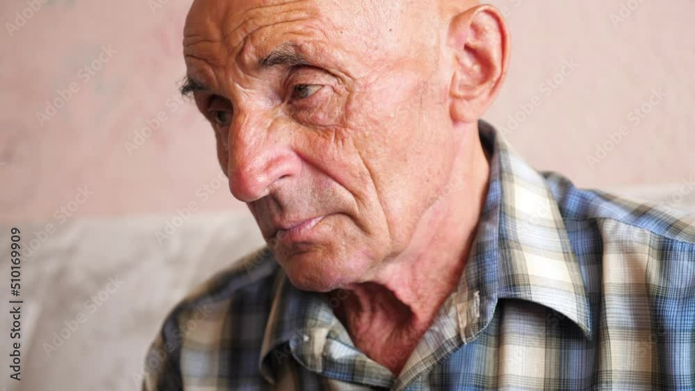 The sad look of an elderly Caucasian man. Senior citizen 70-79 years old serious portrait. The theme of loneliness and depression, nursing home. Problems in old age.Selective focus The sad look of an elderly Caucasian man. Senior citizen 70-79 years old serious portrait. The theme of loneliness and depression, nursing home. Problems in old age.Selective focus