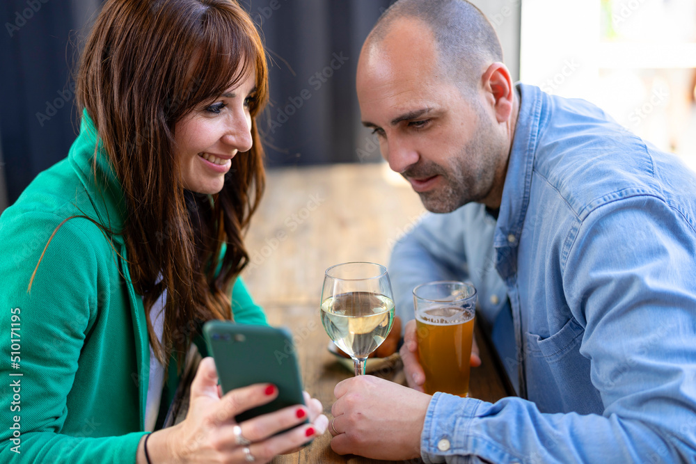 Adult couple using smartphone in restaurant Adult couple using smartphone in restaurant