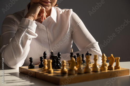 Fotografie, Obraz Faceless caucasian woman in white shirt playing chess.