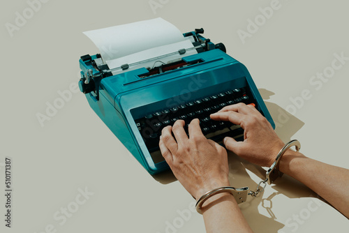 man wearing handcuffs typing in a typewrite photo