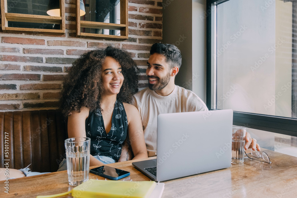 Couple Sitting In Cafe And Using Laptop Couple Sitting In Cafe And Using Laptop