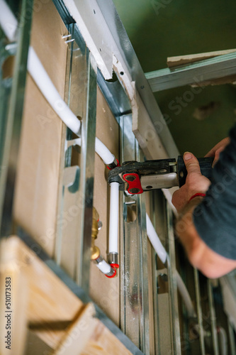 Handyman installing piping system near ceiling