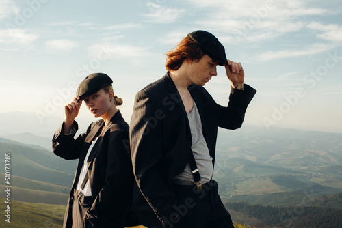 Stylish couple in caps on the background of mountain landscapes