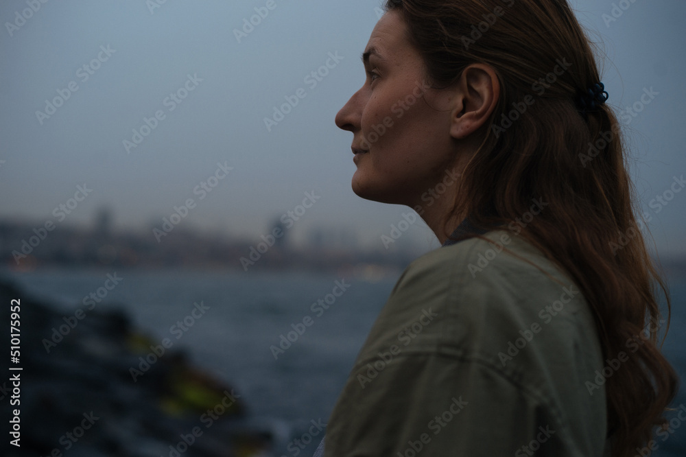 woman looking at a cityscape from the coast woman looking at a cityscape from the coast