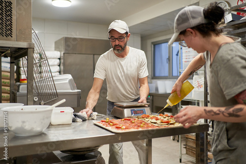 Male and female cooks working in kitchen