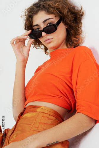 Portrait of intrigued relaxed woman in orange clothes