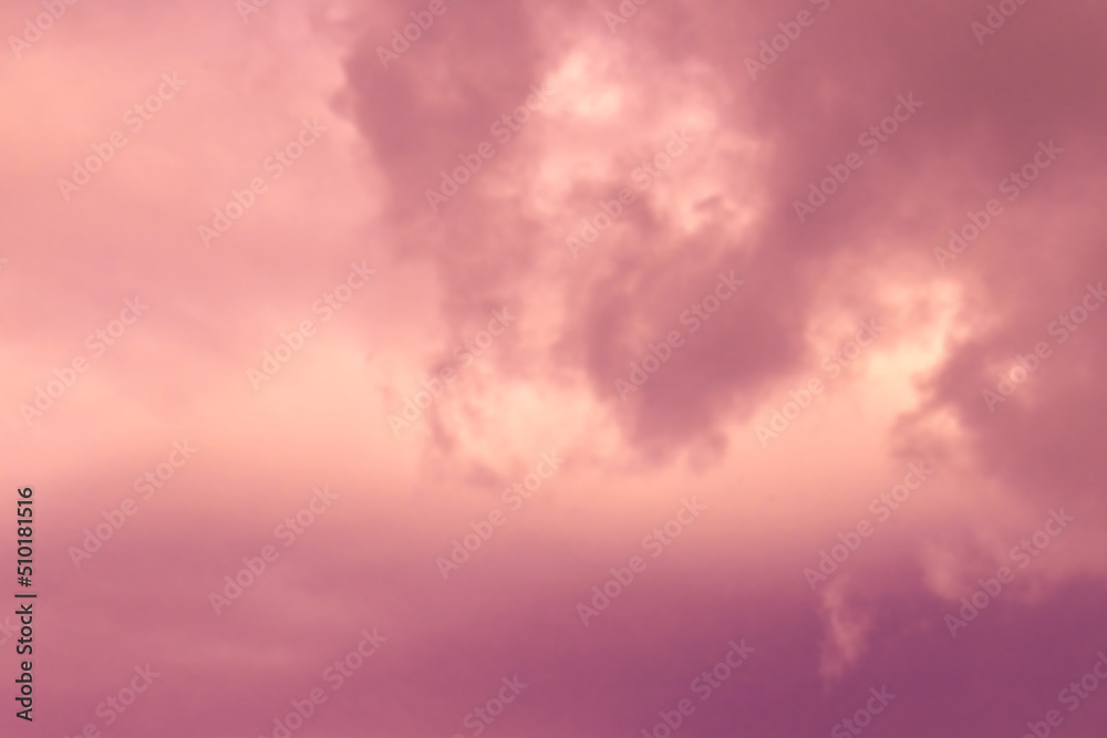 Dramatic sunset sky background. Blurred photo of purple, yellow, orange and brown sky with fluffy clouds.