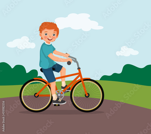 happy little boy riding a bike having fun in the park on sunny day 