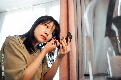 Young woman applying makeup in the morning photo