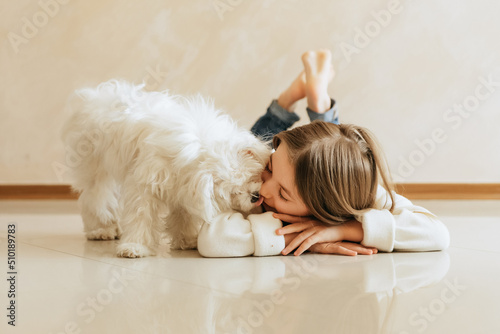 girl 9 years old with long hair model with a pet dog Maltese schoolgirl at home lifestyle on a beige background allergy veterinarian