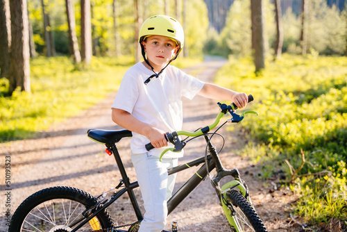 Fototapeta Naklejka Na Ścianę i Meble -  Cute child boy cycling though forest in summer vacation.