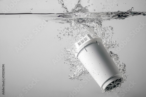  water filter dropped into the water on a white background