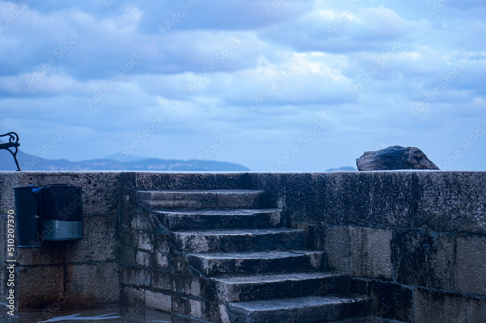 Old Ancient Stones of Dubrovnik with Copy Space on Top. Rainy weather, Clouds, Dusk, Stormy. Europe, Hrvatska. Stair. Old Ancient Stones of Dubrovnik with Copy Space on Top. Rainy weather, Clouds, Dusk, Stormy. Europe, Hrvatska. Stair.