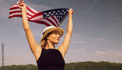 Young woman in a hat with the USA flag on a blue sky background. FLAG DAY. holiday american