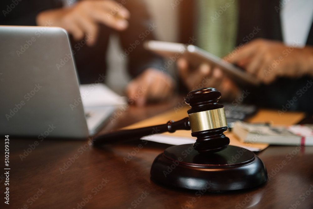 Justice and law concept.Male judge team in a courtroom the gavel, working with digital tablet computer on wood table. Justice and law concept.Male judge team in a courtroom the gavel, working with digital tablet computer on wood table.