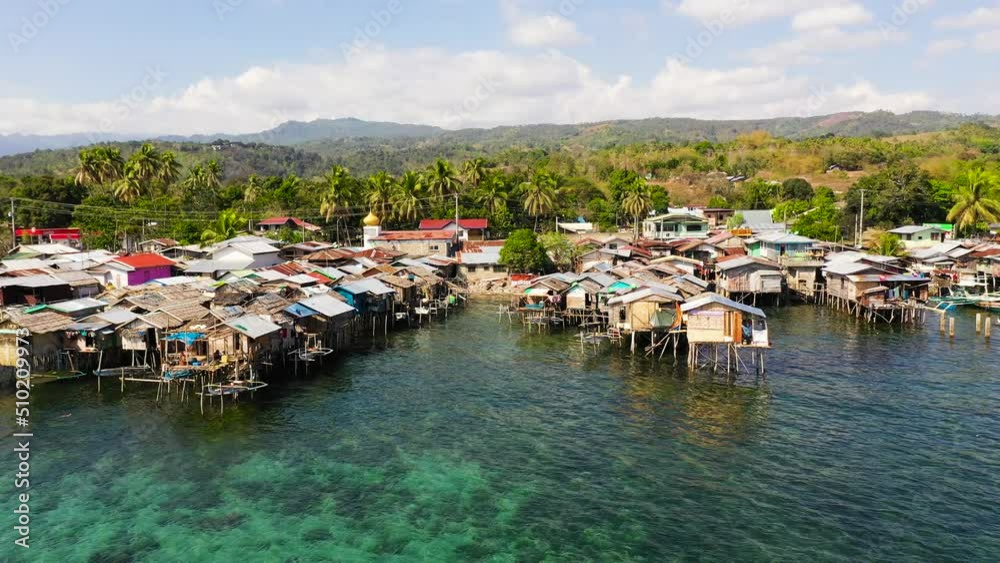 Traditional fishing village in Asia with fishing boats and houses standing in the sea. Philippines, Mindanao. Traditional fishing village in Asia with fishing boats and houses standing in the sea. Philippines, Mindanao.